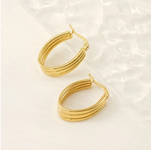 Detailed macro view of triple-layered gold hoop earrings with mirror polished finish