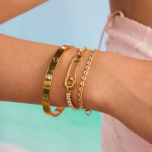 Women's gold stainless steel layered bracelets set with heart charms and clear zircon stones