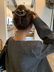 Dettaglio del fermaglio per capelli a cuore con perle e cristalli grigio scuro sui capelli