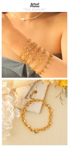 Close-up of gold plated stainless steel layered chain bracelets with lobster clasp detail