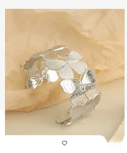 Detailed close-up of a silver butterfly cuff bracelet with intricate carved wing textures