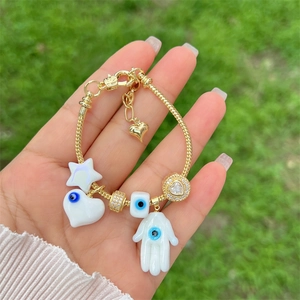 18K gold plated Hamsa Hand and Evil Eye charm bracelet with adjustable chain on hand