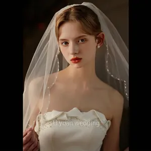 Elegant white bridal veil with hand-stitched pearls and matching wedding dress