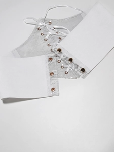 Detail of white lace waist cincher showing metallic eyelets and satin ribbon lacing