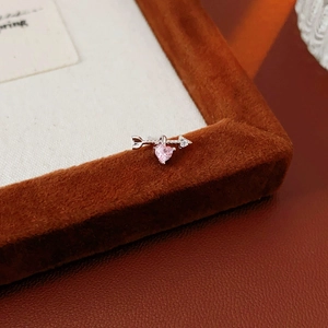 Close-up of pink heart zircon pendant on silver arrow earring in velvet box
