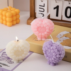 Detailed view of heart-shaped rose textured scented candle on wooden tabletop
