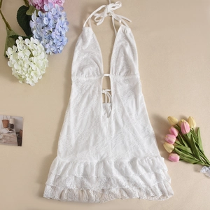 Detailed flat lay of a white lace halter dress with ruffled hem and floral accents