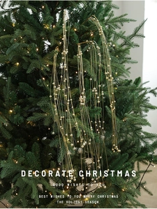 Gros plan sur une guirlande de perles dorées de Noël avec finition métallique brillante