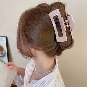 Close-up of pink rectangular matte hair claw clip on brunette hair, elegant back view