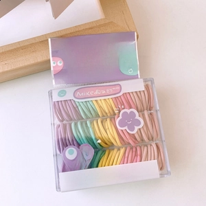 Detail of colorful mini seamless hair ties in a clear box for baby styling
