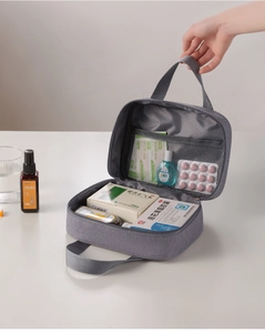 Detail view of the open grey travel first aid bag with internal mesh pockets and main storage