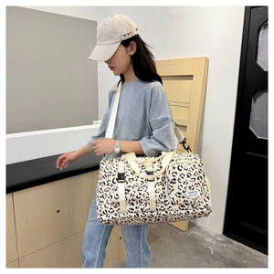Large capacity leopard print travel duffel bag shown carried by a model for scale