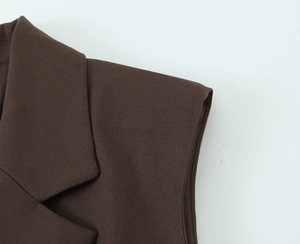 Detail of notched lapels and shoulder tailoring on a dark brown sleeveless waistcoat