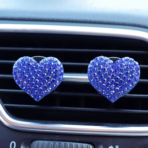 Detail of two blue rhinestone heart car vent clips installed on air outlet