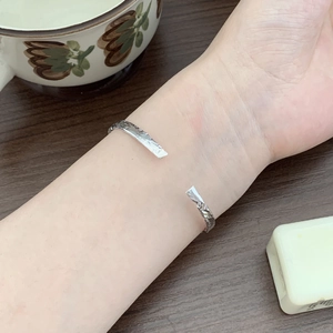 Detailed view of silver irregular lava texture open bangle on wrist with vintage styling