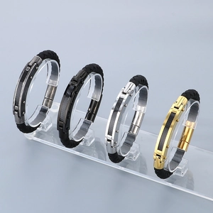 Macro detail of men's braided leather bracelets with gold, silver, and black metal clasps