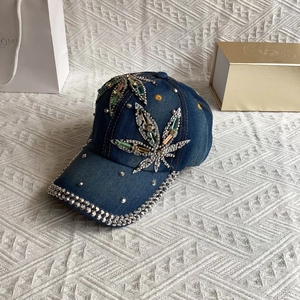 Detailed close-up of maple leaf rhinestone pattern on a dark blue denim baseball cap