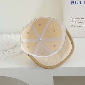 Detail view of the beige baby cap interior showing reinforced seams and brand label