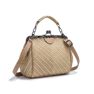 Detail of khaki straw texture and PU leather straps on retro clip handbag for women
