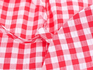 Makro-Detail von rot-weißem Gingham-Seersucker-Stoff mit Knotendesign und Textur