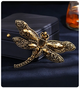 Detailed view of dragonfly brooch back with safety pin clasp on a blue jewelry box