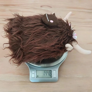 Detailed view showing the Highland Cow plush toy weighing approximately 144.8g on a digital scale