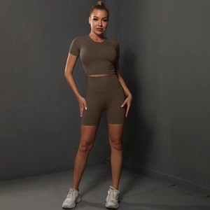 Detail showing seamless dark brown fabric texture on high-waist yoga shorts and top