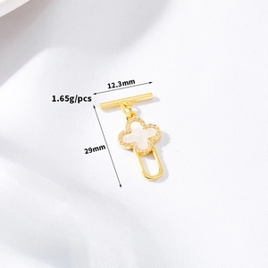 Detailed view of a gold clover OT clasp with white shell inlay and sparkling zircons