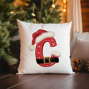 Christmas pillow cover with festive red letter C and Santa hat in a cozy holiday setting