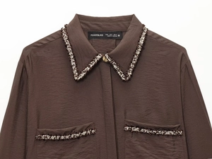 Detail of coffee brown textured blouse with black and gold tweed trim on the collar