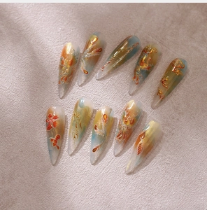 Detail van Stiletto nagels met feniks motieven en goudfolie in Neo-Chinese stijl