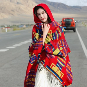 Ethnic style hooded red shawl with geometric patterns and fringe on desert highway