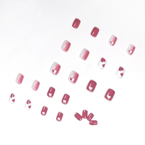 Pink and white gradient press-on nails with heart patterns in a sweet minimalist style