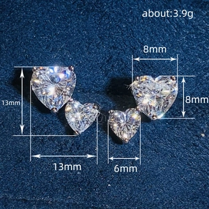 Elegant silver heart earrings with sparkling white zircons on blue velvet background