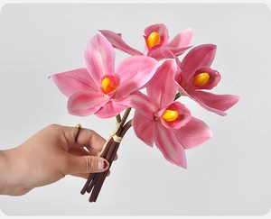 Detailed view of 4-head pink artificial cymbidium orchid flowers with vibrant yellow center