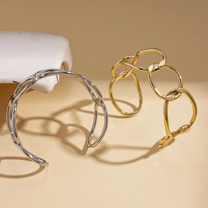 Minimalist geometric irregular wrap open bangle in polished gold and silver metal finishes
