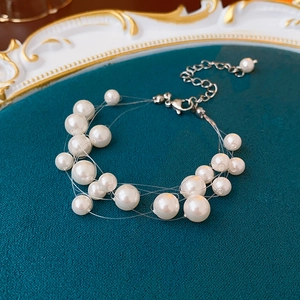 Macro view of multi-layer pearl necklace with silver lobster clasp and extension chain