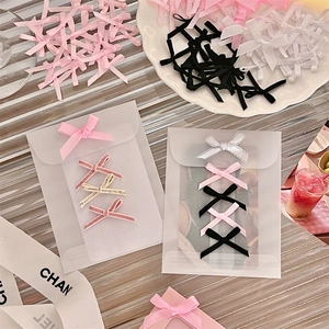 Detailed view of colorful DIY ribbon bows on frosted plastic packaging bags for craft decor
