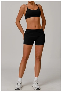 Détail d'un ensemble brassière de sport et short de yoga noir sur un mannequin fitness