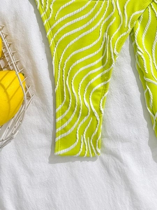 Macro detail of neon green bikini bottom with 3D wave texture on white linen background