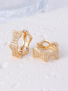 Detailed view of wave-edged gold earrings with micro-pave white zircon stones