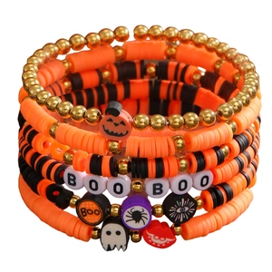 Detail of Halloween beaded bracelets with pumpkin, ghost, and spider charms on white backdrop