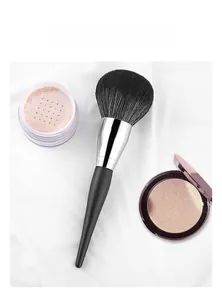 Detailed view of large fluffy powder brush with soft black bristles and matte handle