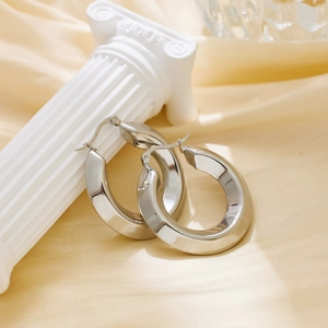 Macro detail of silver chunky hoop earrings with a polished finish and latch back closure