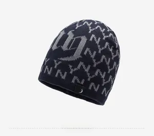 Detail of dark blue knit beanie with gray NY pattern and woven side label