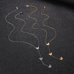 Detailed view of butterfly pendants on stainless steel necklaces in gold and silver finish