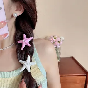Set of two realistic starfish hair clips in pink and white for trendy beach vacation hair styling