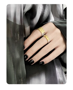 Detail of silver and gold textured ring with irregular foil texture on model's hand