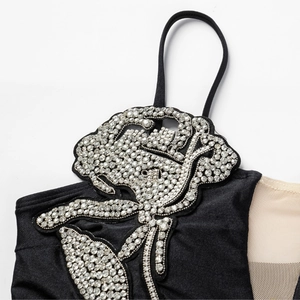 Black one-piece swimsuit featuring sparkling rhinestone rose applique and mesh detail