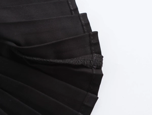 Vue détaillée des coutures de l'ourlet et de la texture plissée d'une robe en tweed